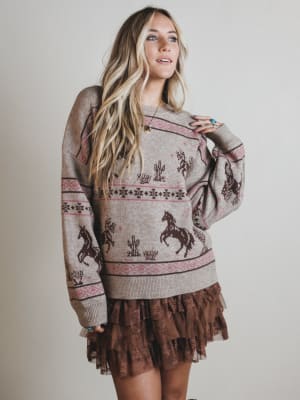 Woman wearing a patterned sweater and skirt with a neutral background
