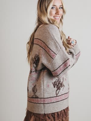 Woman wearing a patterned sweater with a plain background