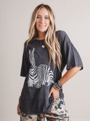 Woman wearing a black t-shirt with a zebra graphic on a plain background