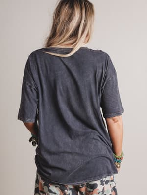 Person wearing a dark gray t-shirt with a neutral background