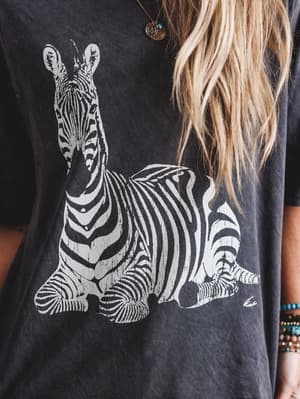 Person wearing a black t-shirt with a white zebra graphic