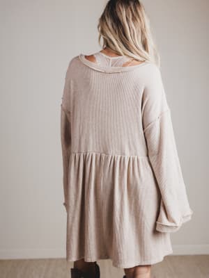 Beige dress worn by a person against a plain background