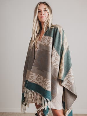 Woman wearing a patterned blanket draped over her shoulders against a plain background
