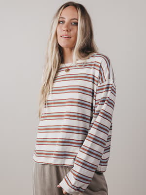 Woman wearing a striped long-sleeve shirt against a plain background