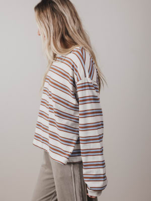 Person wearing a striped long-sleeve shirt against a plain background