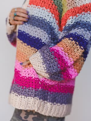 Colorful crocheted cardigan with a pattern of multicolored yarn.
