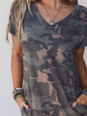 Person wearing a camouflage dress a plain background