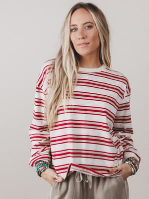 Woman wearing a red and white striped sweater against a plain background