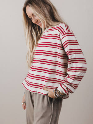 Woman wearing a red and white striped shirt against a plain background