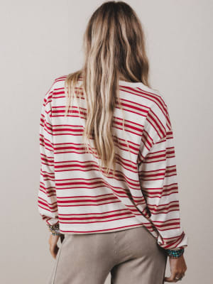 Person wearing a red and white striped shirt with a neutral background