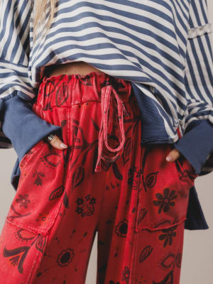 Person wearing red patterned pants with a blue and white striped shirt.