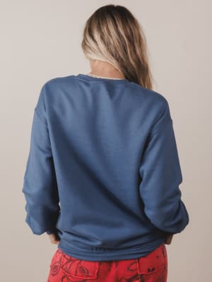 Person wearing a blue sweatshirt with a plain background