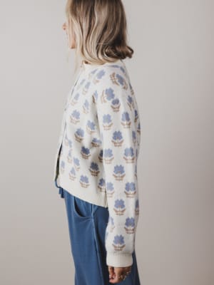 Person wearing a patterned sweater with a neutral background