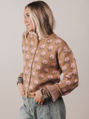 Woman wearing a floral patterned cardigan against a plain background