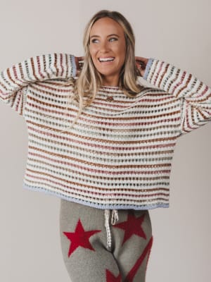 Woman wearing a striped sweater with a plain background