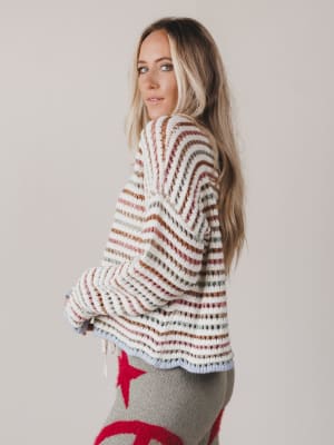 Woman wearing a striped sweater with a plain background