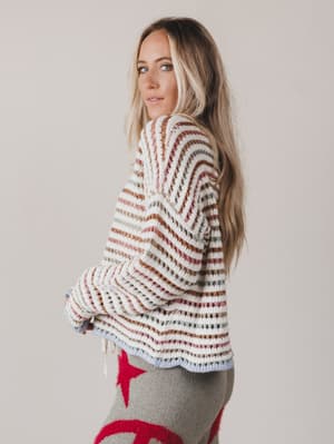 Woman wearing a striped sweater with a plain background