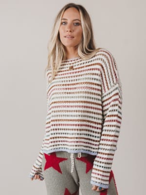 Woman wearing a striped sweater with a neutral background