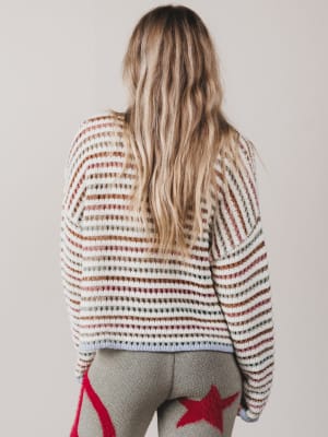 Person wearing a striped sweater with a neutral background