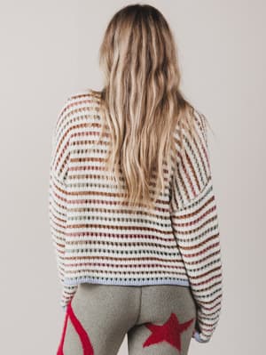Person wearing a striped sweater with a neutral background
