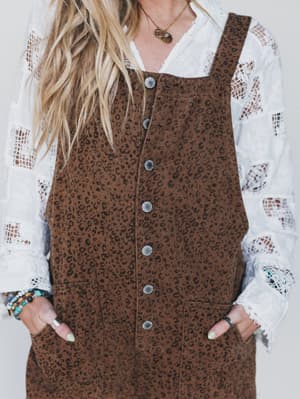 Brown leopard print dress over a white lace top with a plain background