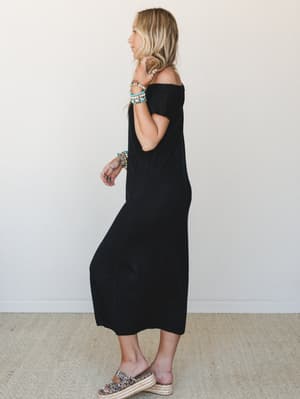 A relaxed black midi dress with an off-shoulder smocked neckline is styled with leopard print platform espadrilles and stacked turquoise and beaded bracelets — effortlessly pulled-together with that 'threw it on and looked great' energy.