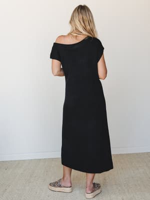 A black knit midi dress shot from the back, styled with leopard print platform espadrilles — effortlessly simple with just enough personality in the footwear to keep it interesting.