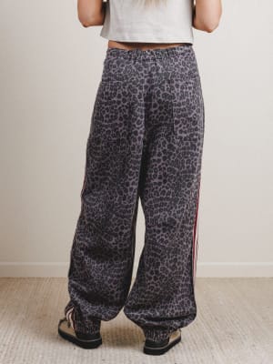 Person wearing leopard print pants with a plain background