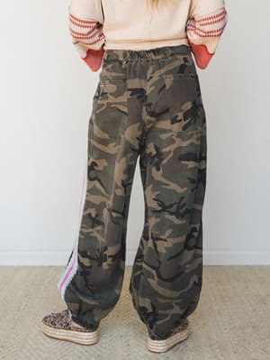 A back-view shot of wide-leg camo pants with a relaxed elastic waist, styled with a mixed-print top and espadrille platform sandals — the kind of outfit that looks effortless but definitely took thought.