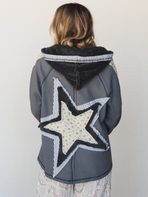 Shot from the back, this charcoal waffle-knit hoodie does all its best talking from behind — a layered star appliqué in seersucker stripe and tiny floral print takes up the whole back, with sherpa-lined hood and raw-edge detail that gives it that per