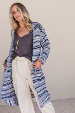 Woman wearing a long blue and white Soul Synced Striped Cardigan against a plain background