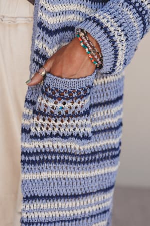 Close-up of a person wearing a blue and white striped sweater with a pocket.