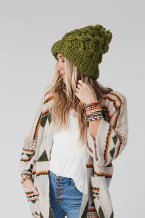 Side view of a person wearing a green knit beanie.