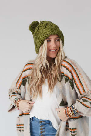 Person wearing a green knit beanie looking to the right.