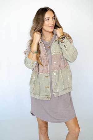 A woman with long hair wears a mauve dress and the Star Dust Contrast Corduroy Jacket - Multi in an oversized fit. She holds the jacket collar with both hands, smiling slightly and looking to the side against a plain background.