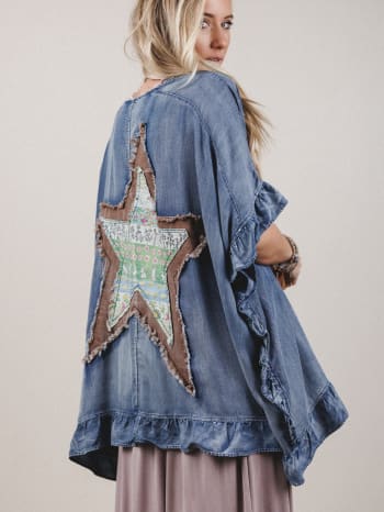 Denim jacket with a star-shaped patch on a plain background