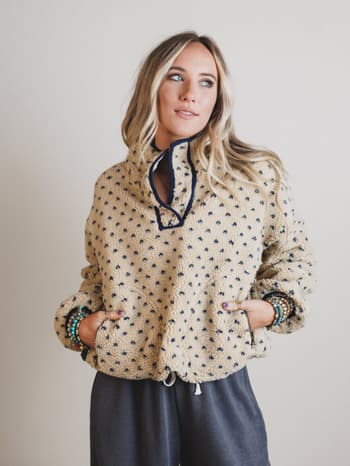 Woman wearing a patterned sweater with a neutral background