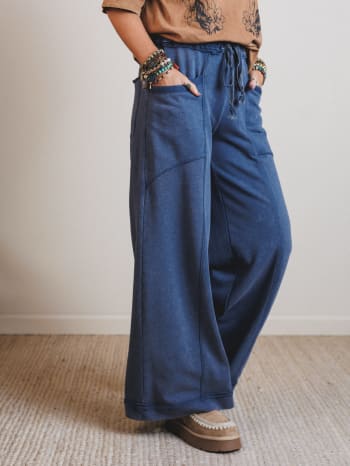 Person wearing blue wide-leg pants with a neutral background